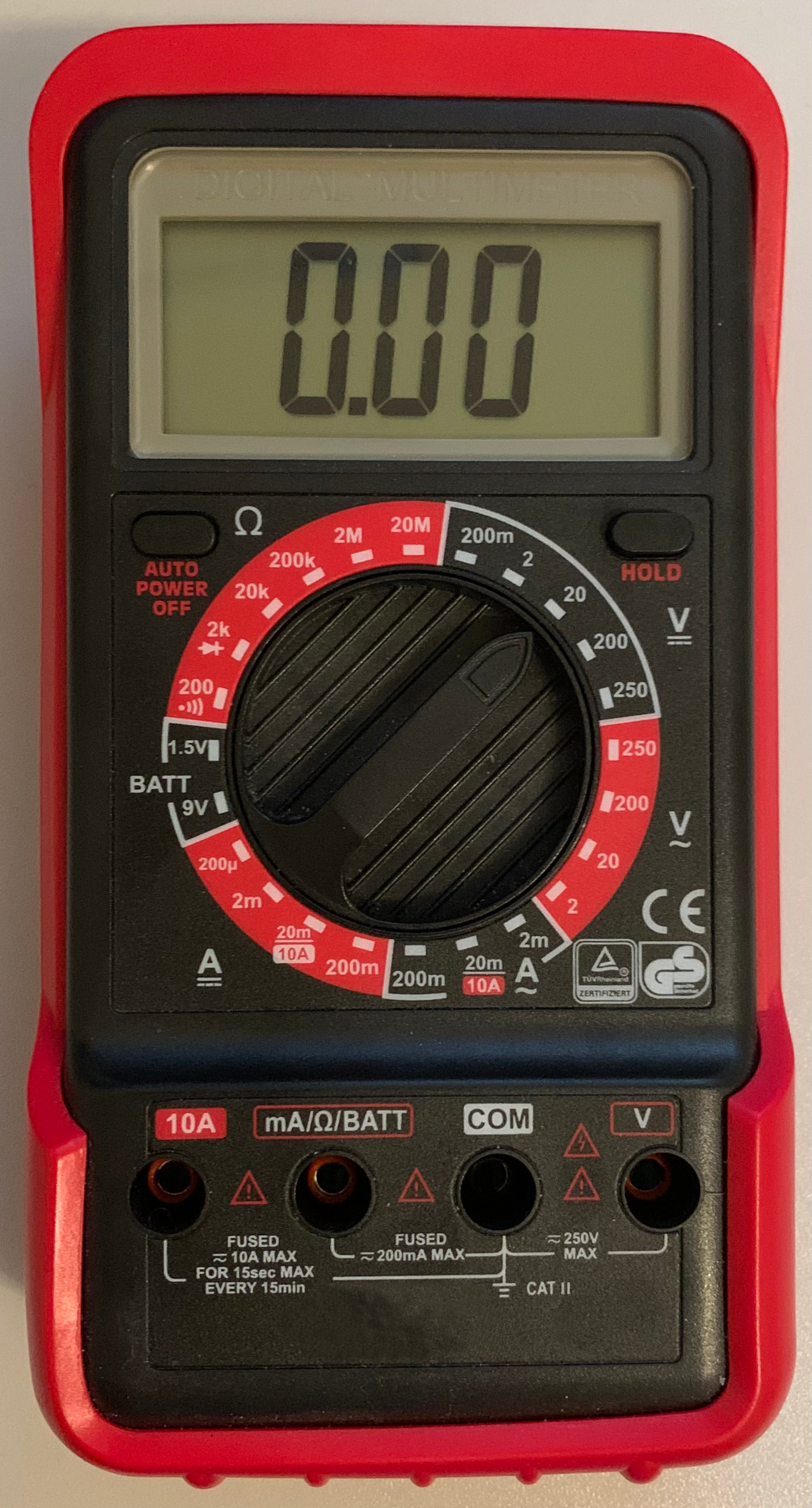 1) Kurzbeschreibung: Digitales Handmultimeter in roter Schutzhülle mit Anzeige „0.00“ und zentralem Drehwahlschalter.
<ol start=