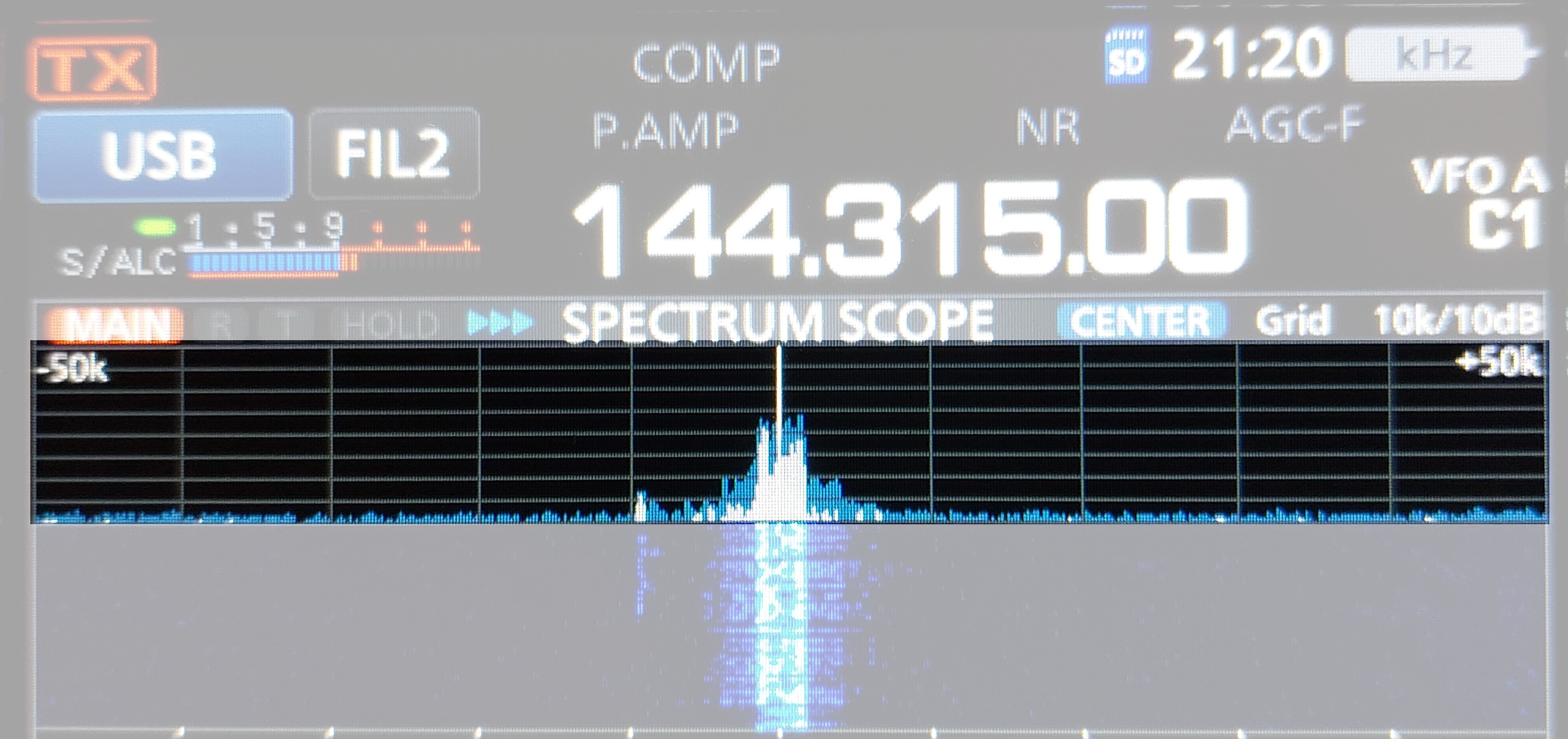 1) Kurzbeschreibung: Display eines Funkgerätes mit Frequenzanzeige „144.315.00“, Spektrums- und hervorgehobene Wasserfalldarstellung eines starken Signals in der Mitte.
<ol start=