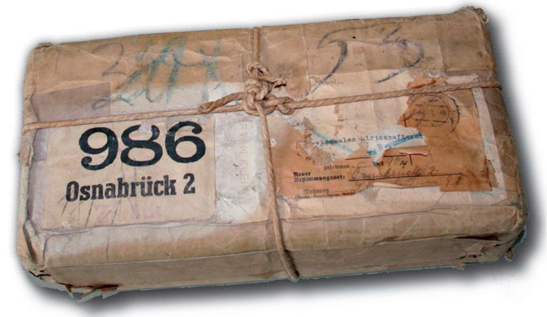 1) Kurzbeschreibung: Quaderförmiges, braun eingepacktes und verschnürtes Paket mit stark abgenutztem Etikett mit der Aufschrift „986 Osnabrück 2“. Inhalt: Backstein zur Beschwerdeführung bei der Verschleppung der Einführung des Amateurfunkgesetzes 1949.
<ol start=