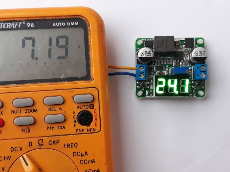 Dieser Alt-Text wurde noch nicht überprüft.
<p>Kurzbeschreibung: Ein oranges Digitalmultimeter liegt neben einer kleinen Elektronik‑Platine mit grünem LED‑Display; das Multimeter zeigt 7.19 V, die Platine 24.1.</p>
<p>Detaillierte Beschreibung: Links dominiert ein abgenutztes, orangefarbenes Hand‑Digitalmultimeter mit großem grauen LCD, auf dem „7.19“ steht, rechts daneben ein kleines „V“. Darunter sind mehrere graue Gummitasten mit Aufdrucken wie „MAX“, „REL“ und „AUTO“, ein schwarzer runder hFE‑Sockel sowie ein Drehschalter mit Skalen für DCV, Ω, CAP und FREQ. Rechts daneben liegt eine kleine grüne Leiterplatte mit bestückten Bauteilen: zwei silberne Elektrolytkondensatoren mit „35V“-Aufdruck, ein schwarzer rechteckiger Induktor, mehrere ICs und Widerstände sowie zwei blaue Schraubklemmen. Auf der Platine leuchtet eine dreistellige grüne 7‑Segment‑Anzeige mit „24.1“. Ein gelbes und ein blaues Kabel sind an eine der Klemmen angeschlossen und führen nach links aus dem Bild. Der Hintergrund ist eine weiße, matte Fläche.">
<figcaption>Abbildung NEA-10.7.1:  Abwärts- (Buck) Aufwärts- (Boost) Wandler. Hier als Aufwärtsspannungswandler von $7,2 V$ auf $24 V$ eingestellt</figcaption></p>
</figure>
Dieser Buck-Boost Converter kann von $0,5&nbsp;V$ bis $25&nbsp;V$ am Ausgang eingestellt werden. Die maximale Leistung beträgt $25&nbsp;W$. Da der Wirkungsgrad sehr hoch ist, kommen die Schalttransistoren ohne Kühlkörper aus.  Die Betriebsart Abwärtswandler (Step Down = Buck Mode) oder Aufwärtswandler (Step Up = Boost Mode) kann mit dem rechten Minischalter aktiviert werden.
</aside>

                        </div>
                    </article>
                </main>

                <aside class=