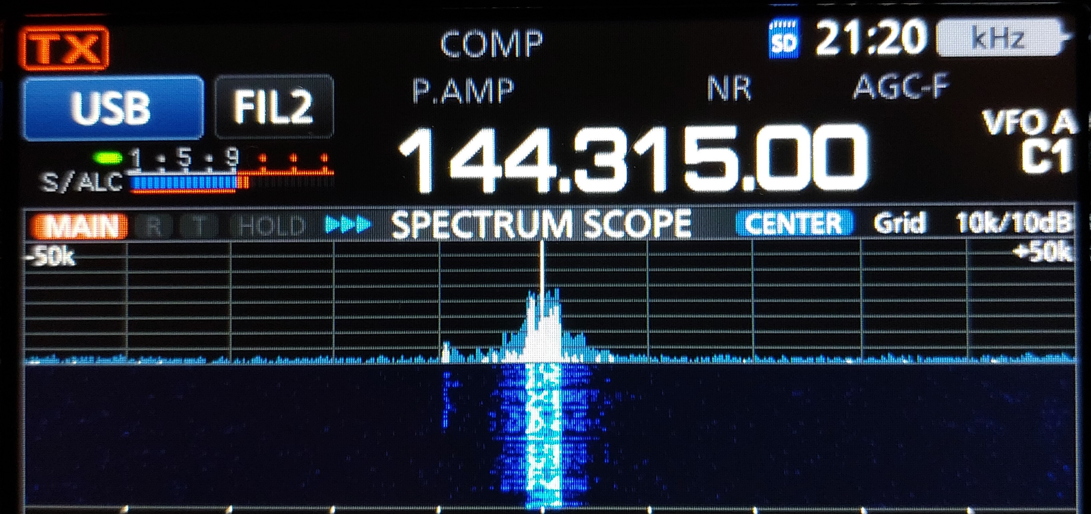 1) Kurzbeschreibung: Display eines Funkgerätes mit Frequenzanzeige „144.315.00“, Spektrums- und Wasserfalldarstellung eines starken Signals in der Mitte.
<ol start=
